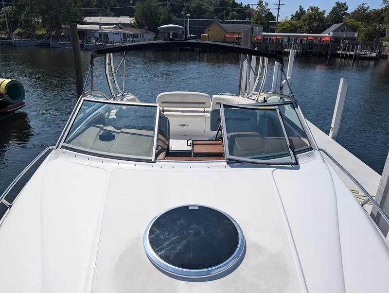 Slide: The Image of 2007 Cobalt 323 boat docked at marina, featuring open deck and windshield. - 7