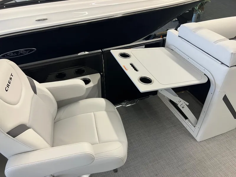 Slide: The Image of 2024 Crest 220 SLC boat interior with white seating and foldable table. - 7