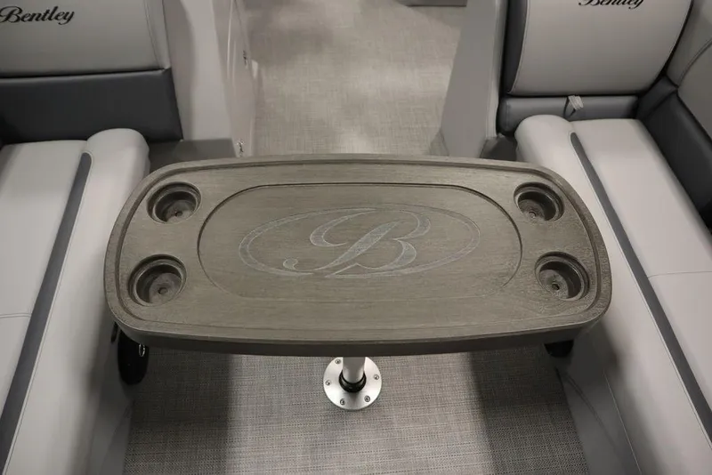 Slide: The Image of 2025 Bentley Pontoons 240 CRUISE interior table with cup holders and logo. - 23