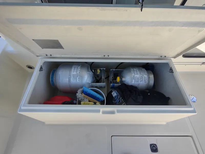 Slide: The Image of Storage compartment on a 2001 Nordic Tug 32, containing propane tanks and cleaning supplies. - 11