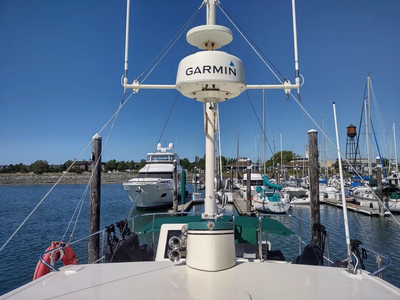 Slide: The Image of 2001 Nordic Tug 32 docked at marina with Garmin radar, clear blue sky. - 14