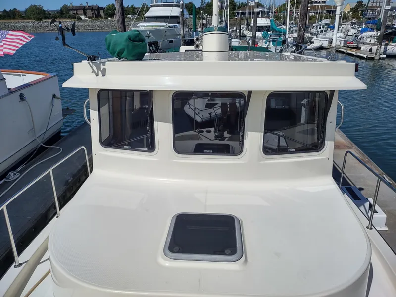 Slide: The Image of 2001 Nordic Tug 32 docked at marina, showcasing cabin and deck. - 15