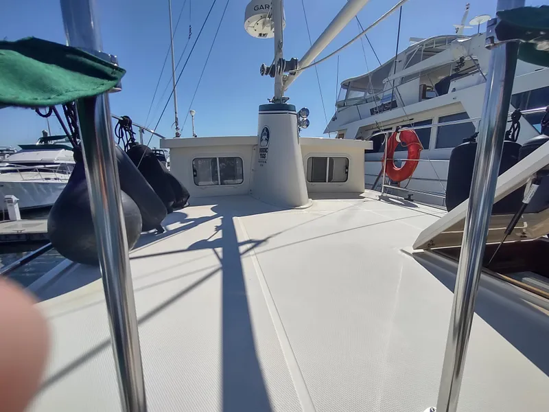 Slide: The Image of 2001 Nordic Tug 32 boat deck with lifebuoy and docked yachts in background. - 16