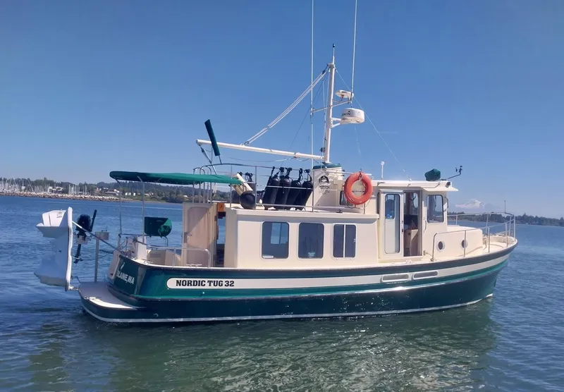 Slide: The Image of 2001 Nordic Tug 32 boat on calm water, featuring classic design and vibrant colors. - 2