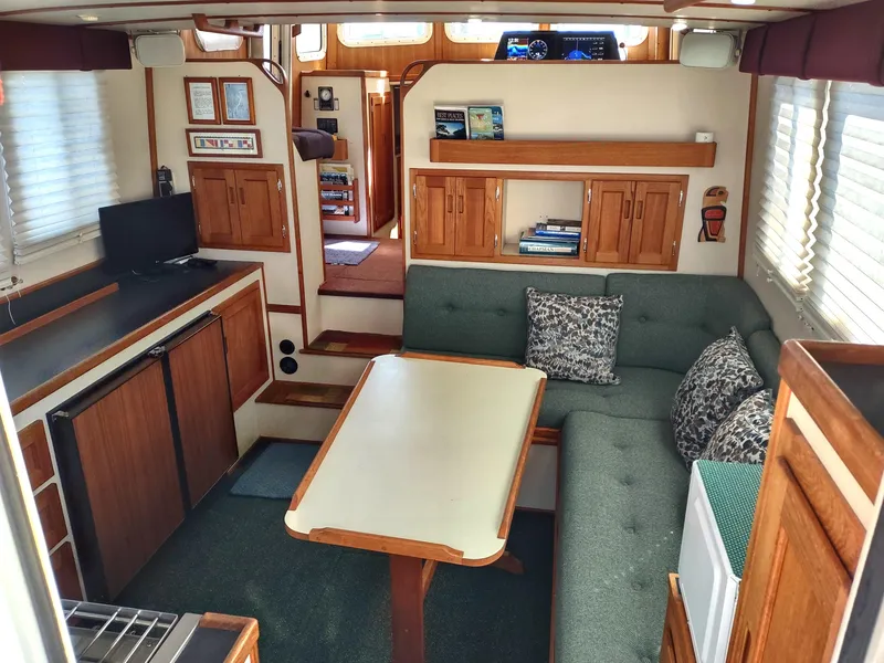 Slide: The Image of Interior of 2001 Nordic Tug 32 with cozy seating and wooden cabinetry. - 20