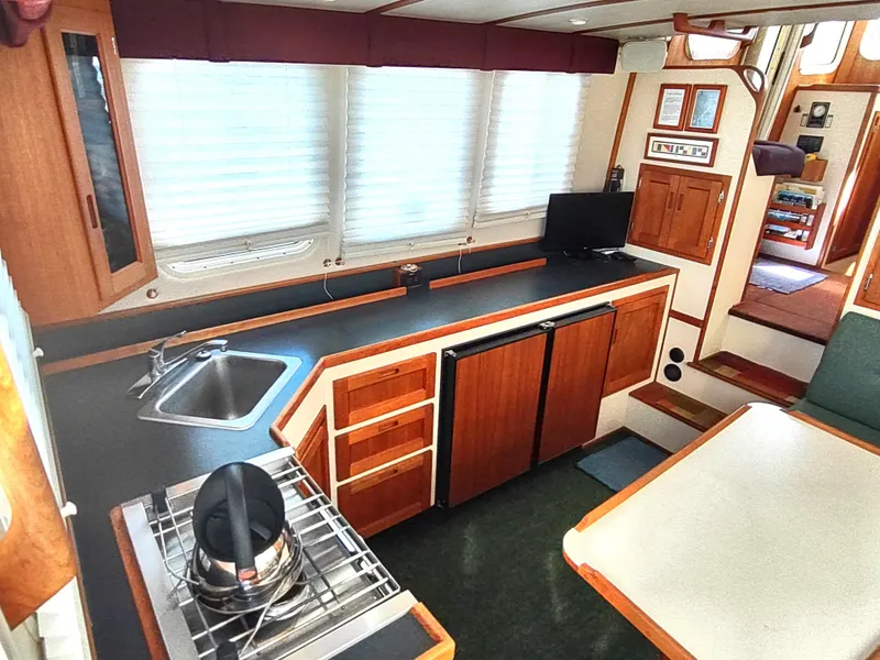 Slide: The Image of Interior of 2001 Nordic Tug 32, featuring kitchen with stove, sink, and compact refrigerator. - 22