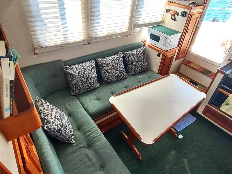 Slide: The Image of Cozy interior of 2001 Nordic Tug 32 with green seating and dining table. - 26