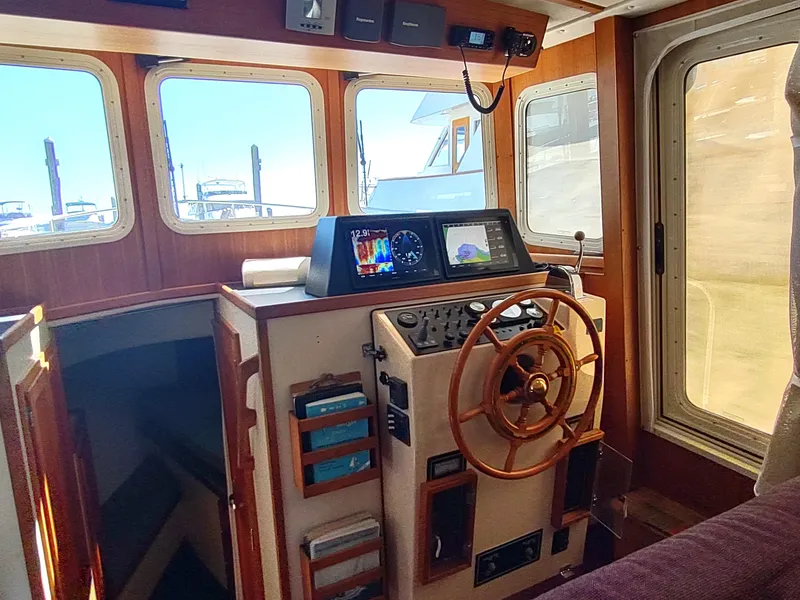 Slide: The Image of 2001 Nordic Tug 32 helm with wooden steering wheel and navigation equipment. - 31
