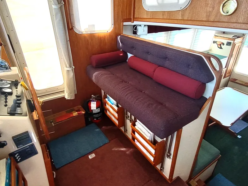 Slide: The Image of Interior of 2001 Nordic Tug 32 with cushioned seating and wooden accents. - 32