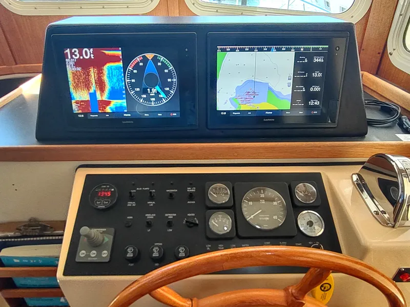 Slide: The Image of Control panel of a 2001 Nordic Tug 32 with navigation displays and gauges. - 36