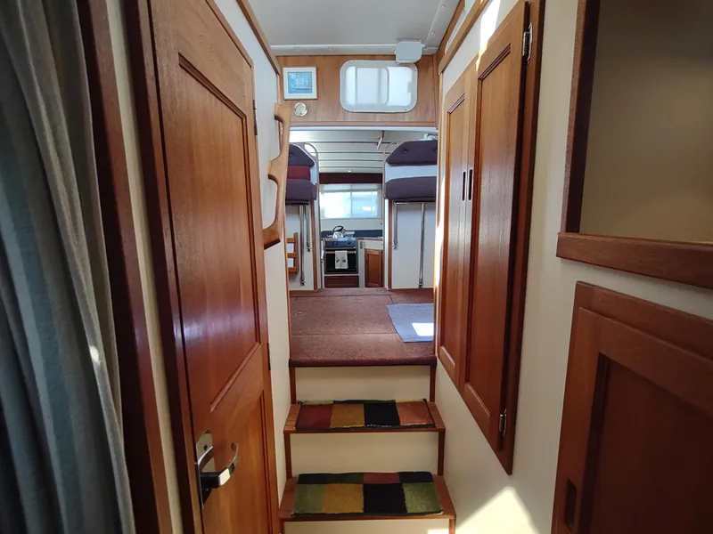 Slide: The Image of Interior of 2001 Nordic Tug 32, featuring wooden cabinetry and cozy cabin layout. - 43