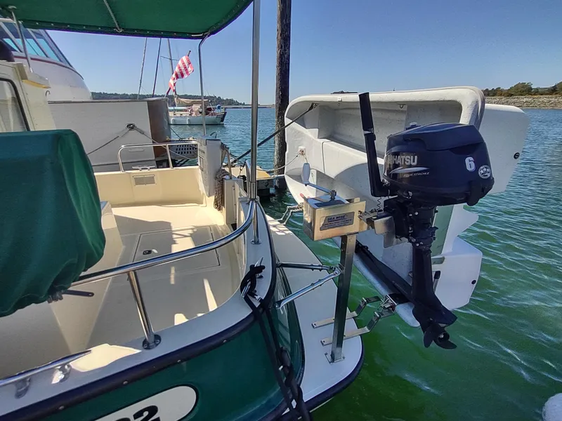 Slide: The Image of 2001 Nordic Tug 32 with Tohatsu outboard motor, docked on calm water. - 6