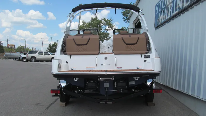 Slide: The Image of 2025 Yamaha Boats 222S, rear view at marina, showcasing sleek design and seating. - 3