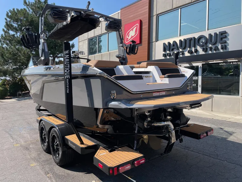 Slide: The Image of 2025 Nautique Super Air Nautique S23 boat at dealership, rear view. - 3