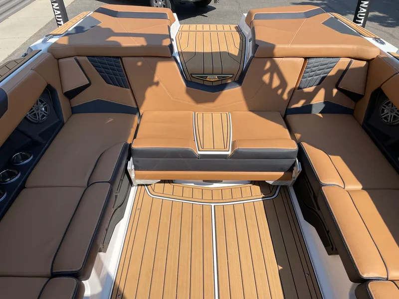 Slide: The Image of 2025 Nautique Super Air Nautique S23 interior with tan leather seating and wood accents. - 8