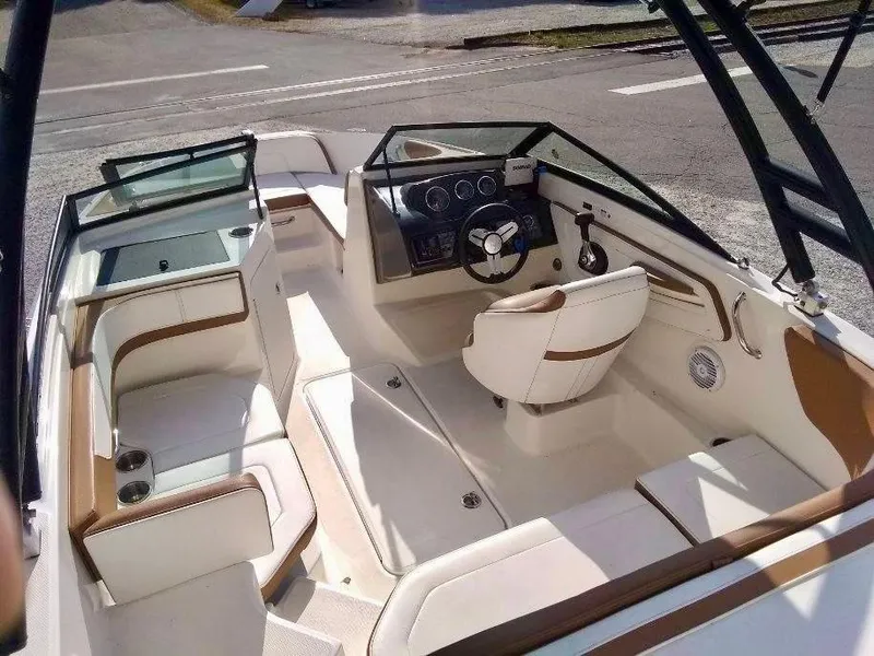 Slide: The Image of 2017 Sea Ray SPX 190 boat interior with white and brown seating, steering wheel, and dashboard. - 2