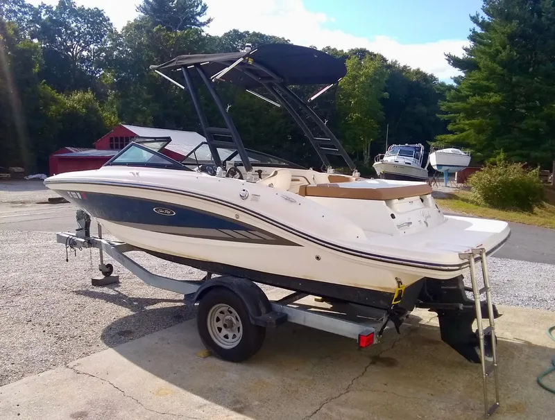 Slide: The Image of 2017 Sea Ray SPX 190 boat on trailer, parked outdoors, with trees in the background. - 7