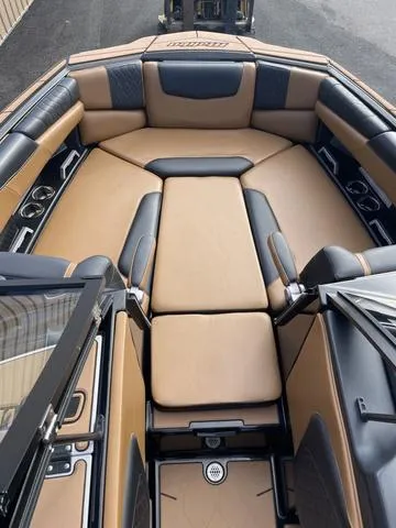 Slide: The Image of 2022 Malibu M220 boat interior with tan and black seating, luxurious design. - 3
