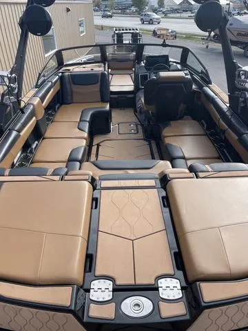Slide: The Image of 2022 Malibu M220 boat interior with tan and black seating, spacious layout. - 4