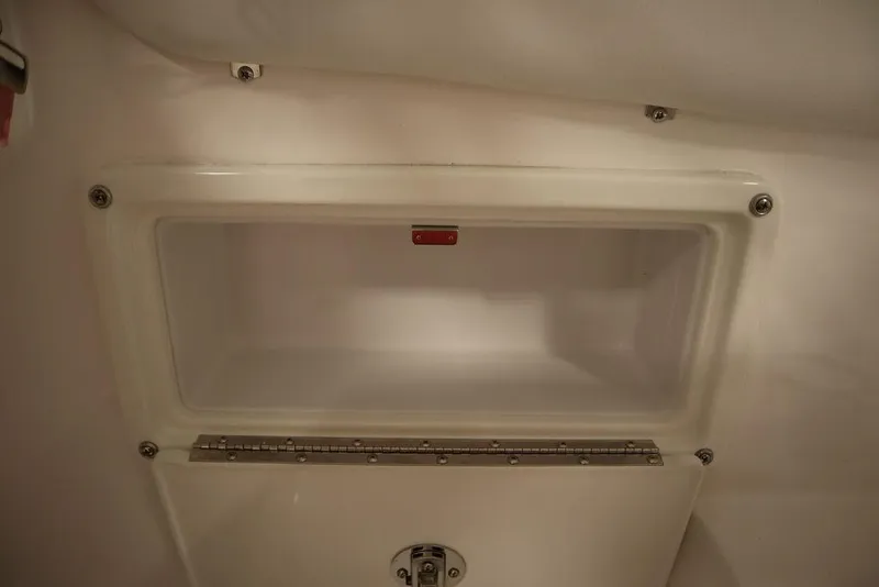 Slide: The Image of 2025 Sea Fox 228 Traveler storage compartment, white interior, secure latch. - 34