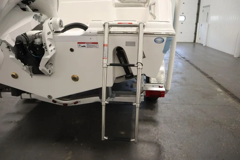 Slide: The Image of 2025 Sea Fox 228 Traveler boat with rear ladder in a garage setting. - 45