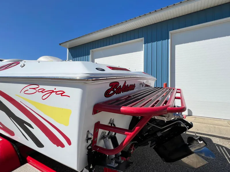 Slide: The Image of 2005 Baja Outlaw boat with vibrant graphics and red accents near a blue building. - 15