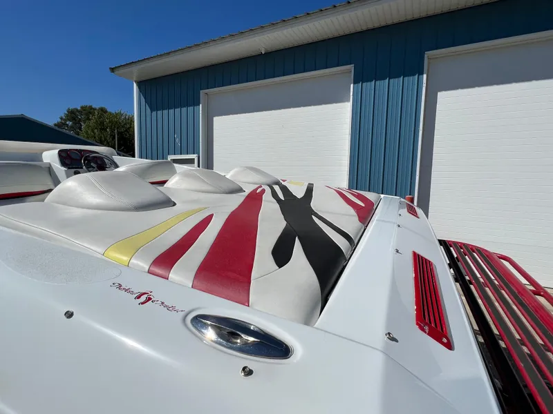 Slide: The Image of 2005 Baja Outlaw boat with colorful upholstery, parked near blue garage doors. - 16
