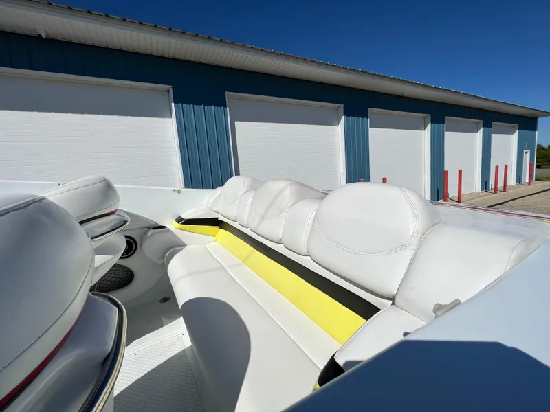 Slide: The Image of 2005 Baja Outlaw boat interior with white seating, parked near blue storage units. - 17
