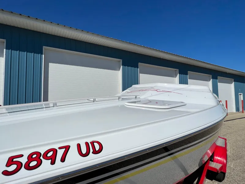 Slide: The Image of 2005 Baja Outlaw boat with registration number 5897 UD, parked near blue warehouse. - 20
