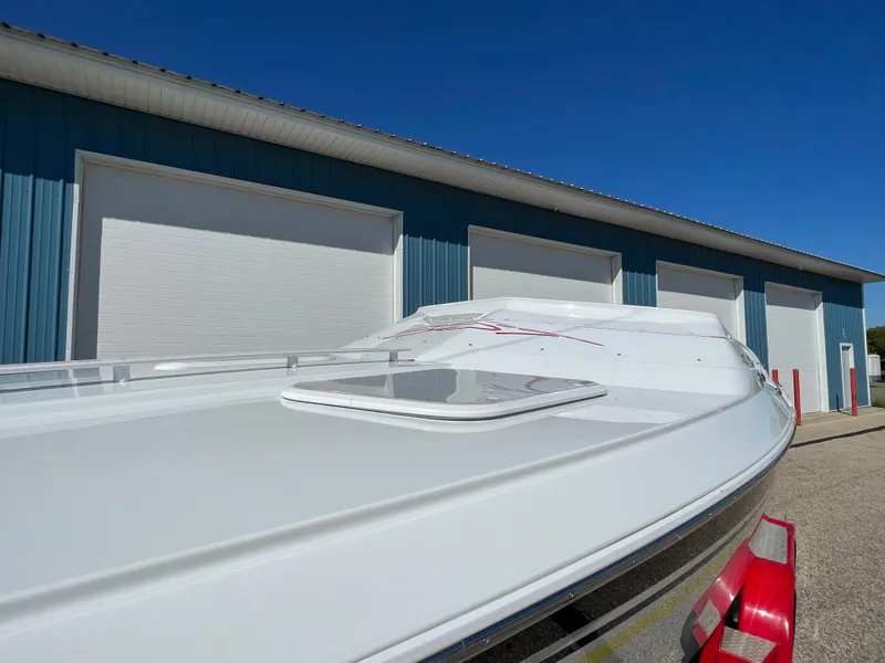 Slide: The Image of 2005 Baja Outlaw boat in front of blue storage units under clear sky. - 21