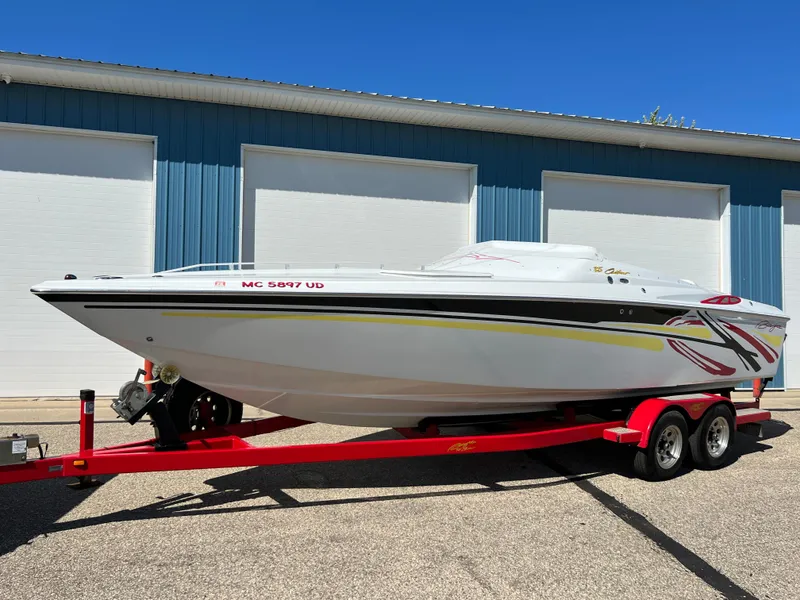 Slide: The Image of 2005 Baja Outlaw boat on red trailer, parked in front of blue garage doors. - 23