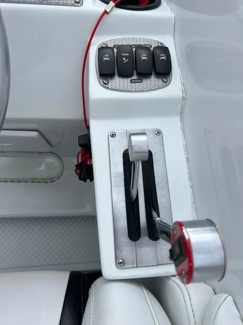 Slide: The Image of 2005 Baja Outlaw boat throttle and control panel with switches. - 34