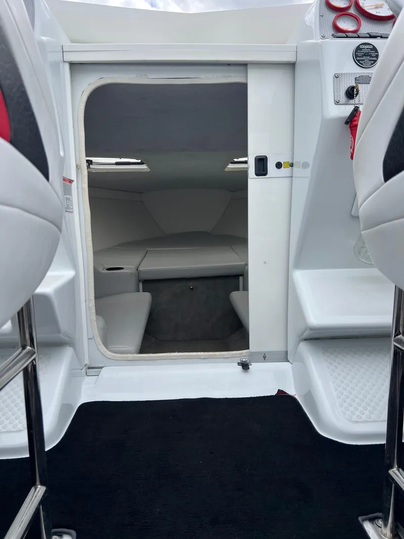 Slide: The Image of Interior cabin view of a 2005 Baja Outlaw boat, featuring white seating and modern design. - 42