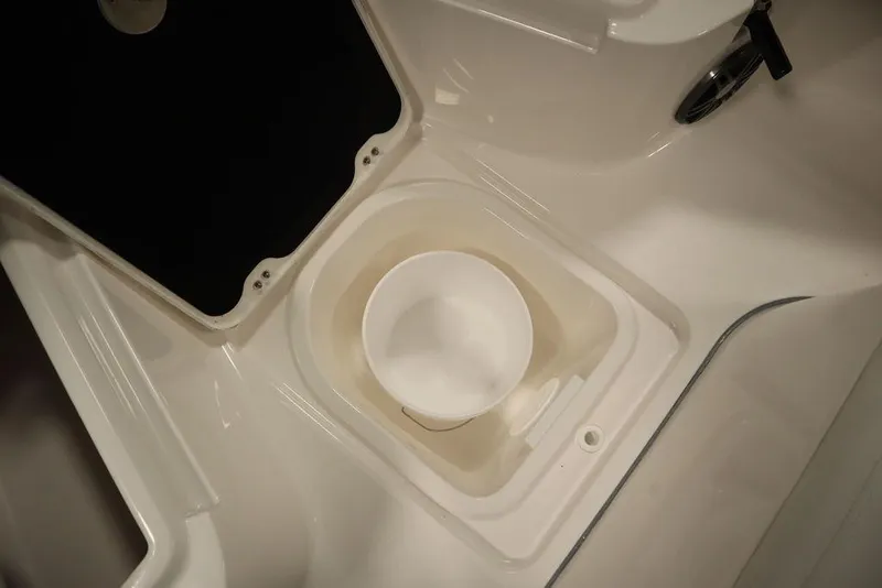 Slide: The Image of 2025 Sea Fox 228 Commander boat storage compartment with white bucket. - 17