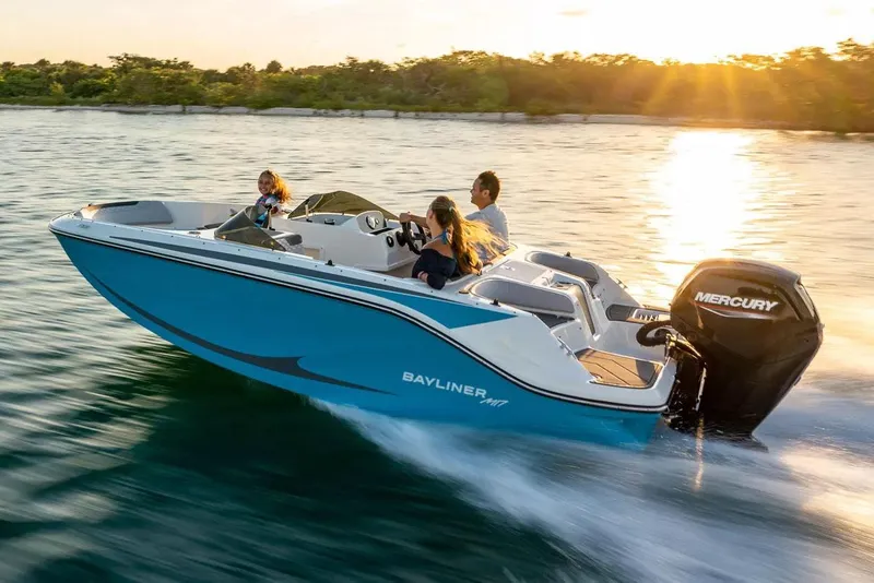 Slide: The Image of 2022 Bayliner Element M17 boat cruising on water at sunset with passengers. - 10