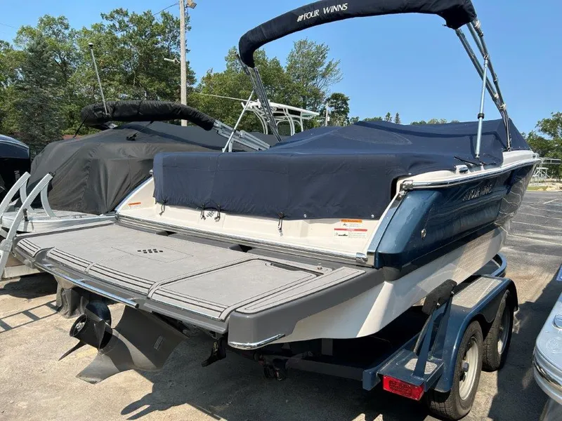 Slide: The Image of 2017 Four Winns H210 boat with cover on trailer, parked outdoors. - 3