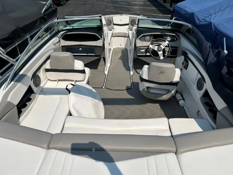 Slide: The Image of 2017 Four Winns H210 boat interior with white and gray seating, steering wheel, and dashboard. - 5