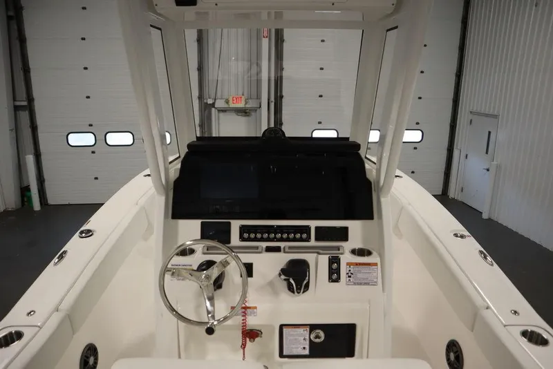 Slide: The Image of 2025 Sea Fox 248 Commander boat console with steering wheel and controls in a garage setting. - 23