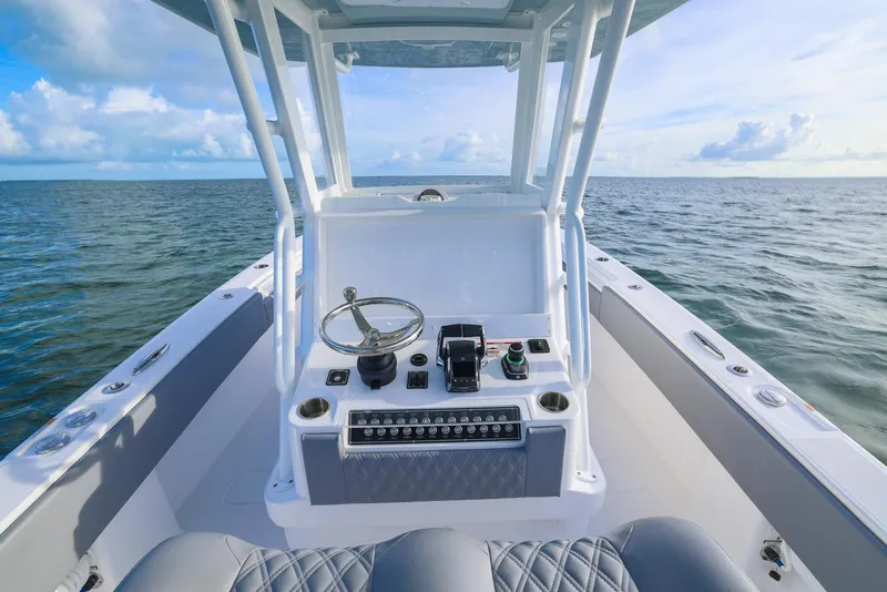 Slide: The Image of 2025 Invincible 33 Open Fisherman boat on open water, featuring modern helm controls. - 22
