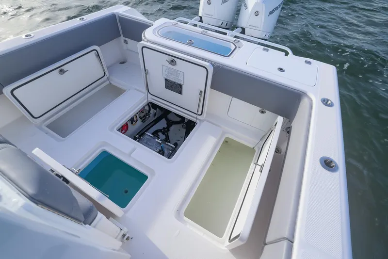 Slide: The Image of 2025 Invincible 33 Open Fisherman boat interior with storage compartments and outboard motors. - 24