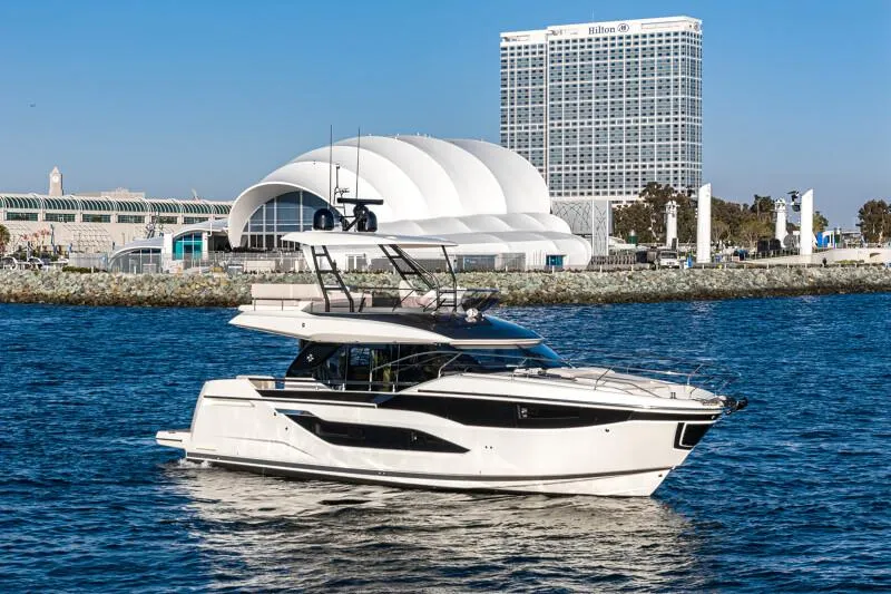 Slide: The Image of Luxurious 2025 Prestige F4.9 yacht deck with seating and table, docked at marina. - 16