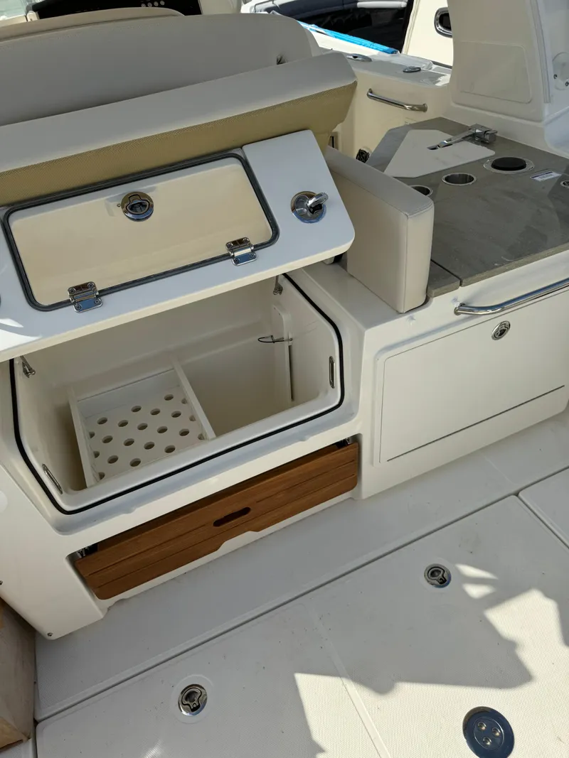 Slide: The Image of 2024 Boston Whaler 350 Realm boat interior with storage compartments and seating. - 10