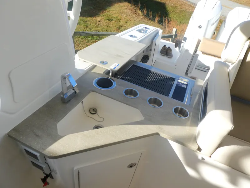 Slide: The Image of 2024 Boston Whaler 350 Realm boat interior with modern kitchenette and seating area. - 11