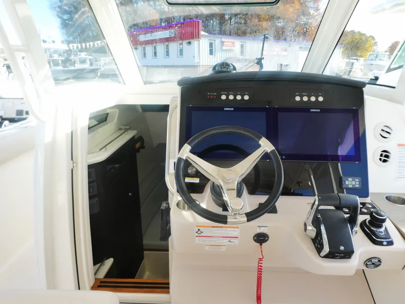 Slide: The Image of 2024 Boston Whaler 350 Realm helm with dual screens and modern controls. - 13