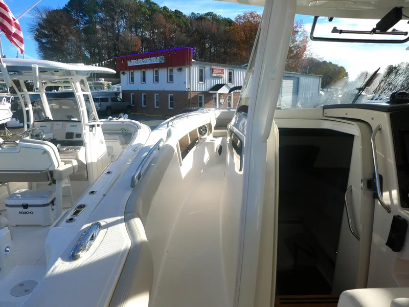 Slide: The Image of 2024 Boston Whaler 350 Realm boat docked at marina, showcasing sleek design and spacious deck. - 14