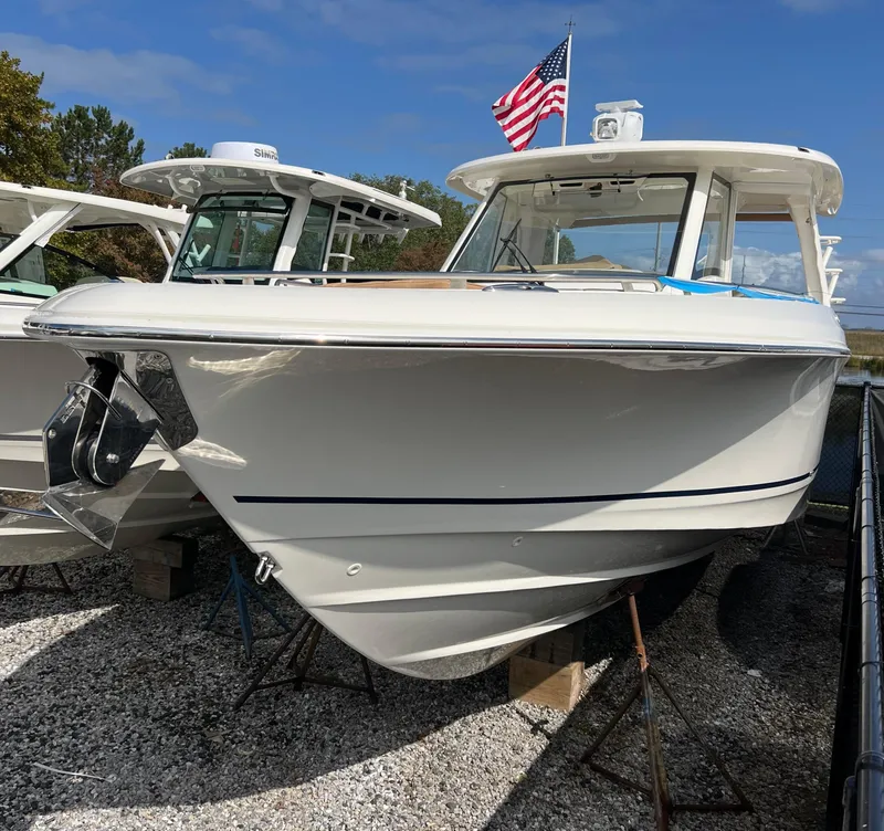 Slide: The Image of 2024 Boston Whaler 350 Realm boat displayed outdoors with American flag. - 2