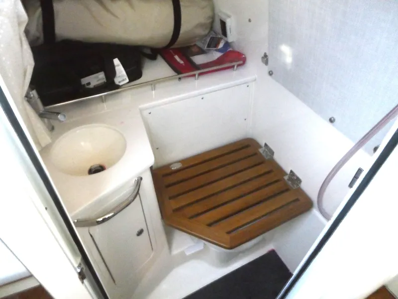 Slide: The Image of 2024 Boston Whaler 350 Realm cabin interior with sink and wooden floor panel. - 22