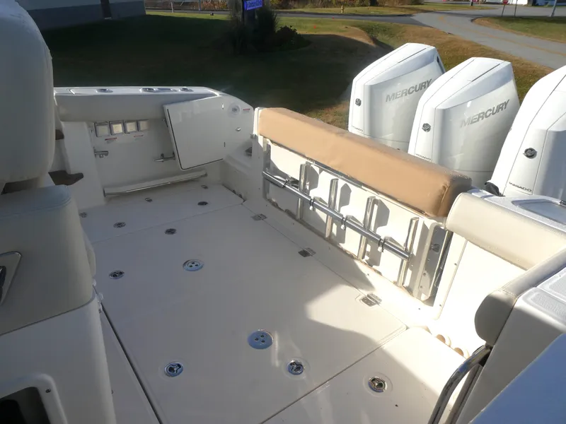 Slide: The Image of 2024 Boston Whaler 350 Realm boat deck with Mercury engines, spacious seating, and storage. - 23