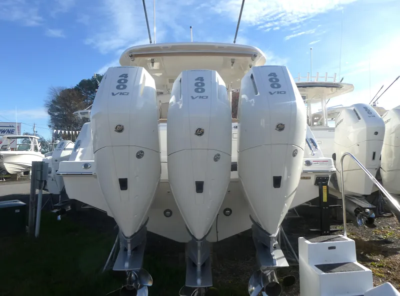 Slide: The Image of 2024 Boston Whaler 350 Realm with triple 400 V8 engines, docked outdoors. - 24