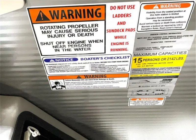 Slide: The Image of Warning labels on a 2024 Bennington 25 RSR boat, highlighting safety precautions and capacity limits. - 13